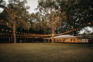 Overall view of the pavilion with lights running through the trees at Country Villa Weddings and events.
