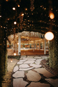 Twinkling lighted arbor leading to the pavilion at Country Villa Weddings and Events.