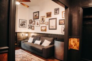 Seating area with comfortable couch and framed photos on the wall in the grooms lounge at Country Villa Weddings and Events.